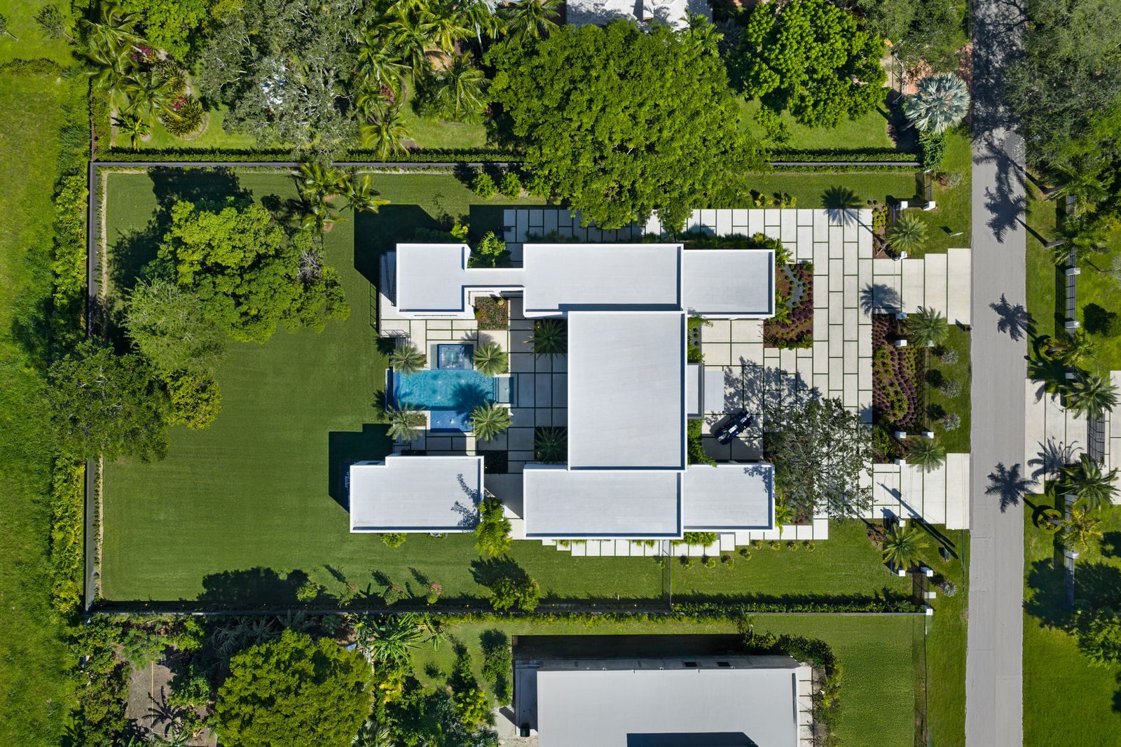 Aerial view of the full gated compound — main residence, guest home, and courtyard pool